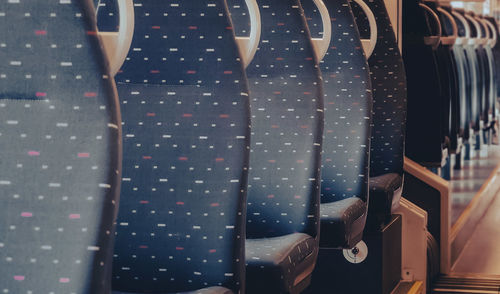 Beautiful geometric view of the seats with gray-blue textile upholstery in a modern belgian train.