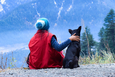 Rear view of person with dog during winter