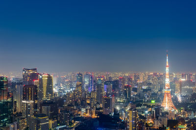 Illuminated buildings in city against sky at night