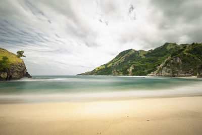 Scenic view of beach and mountains against sky