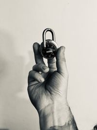 Close-up of hand holding camera against white background