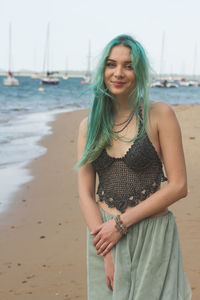 Beautiful young woman standing at beach