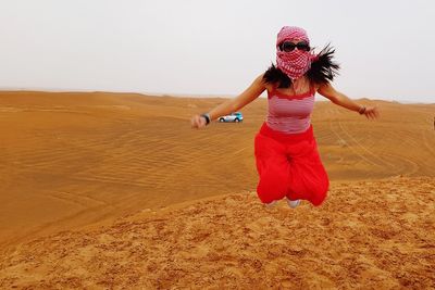 Rear view of woman walking on desert