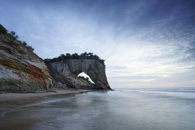 Rock formations in sea against sky