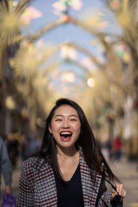 Portrait of smiling young woman standing outdoors