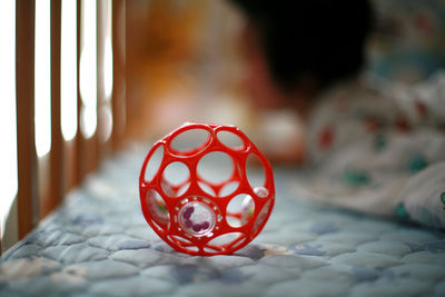 Close-up of red toy in crib