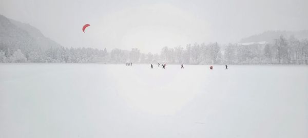 People on snow covered frozen lake