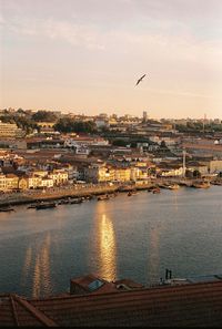 Buildings by river against sky
