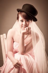 Portrait of young woman sitting in hat