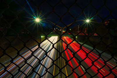 View of illuminated chainlink fence at night