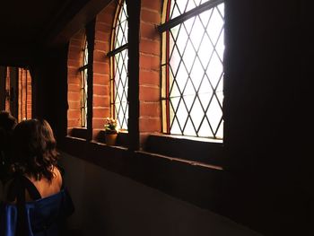 Rear view of woman on window