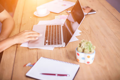 Midsection of man using laptop on table