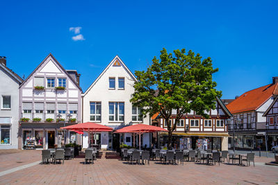 Houses and tables in town against blue sky