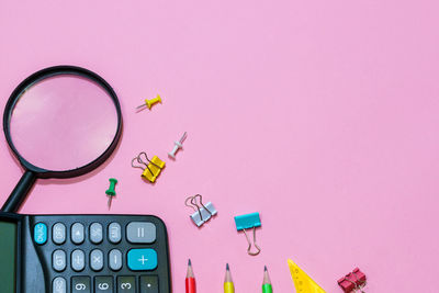 Various office supplies on a pink background. back to school concept.