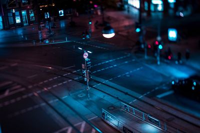 Tilt-shift image of illuminated street in city at night