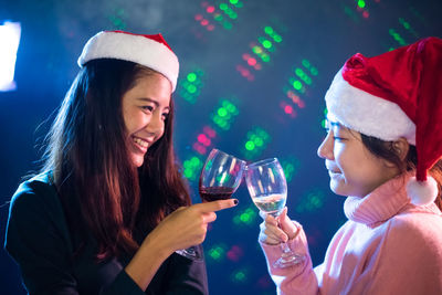Close-up of female friends toasting during christmas