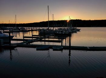 Silhouette boats in water against sky during sunset