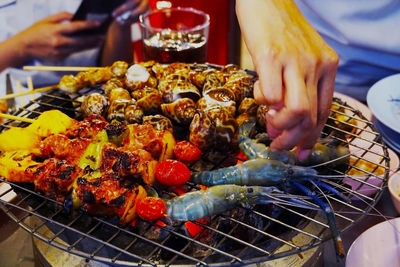 Midsection of person preparing food on barbecue