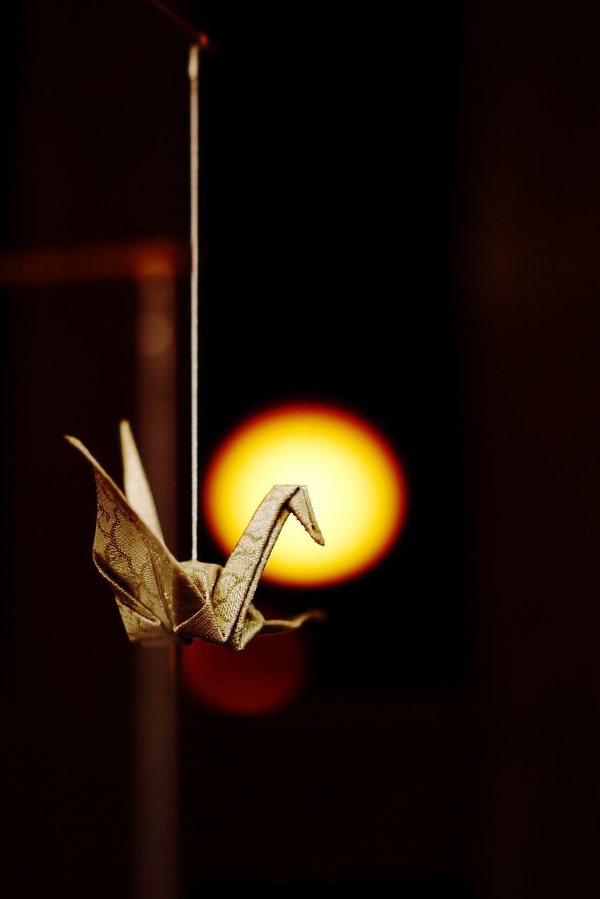 illuminated, indoors, night, copy space, lighting equipment, dark, orange color, close-up, light - natural phenomenon, lit, glowing, no people, single object, focus on foreground, still life, black background, selective focus, art and craft, shadow, red