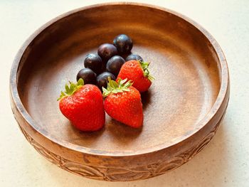 3 strawberries, 7 plums in  wooden bowl. fresh, colourful, juicy, sweet, nutritious, summer fruit.