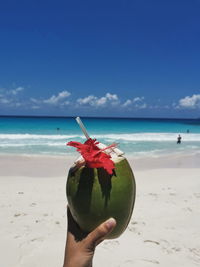 Person holding ice cream on beach