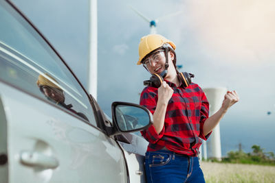 Man looking at camera while standing against car