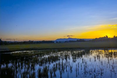 Scenic view of lake against sky during sunset