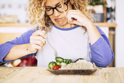 Midsection of woman with ice cream at home