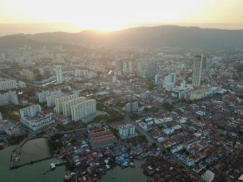 High angle view of city buildings against sky during sunset