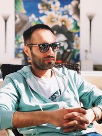 Young man wearing sunglasses sitting outdoors