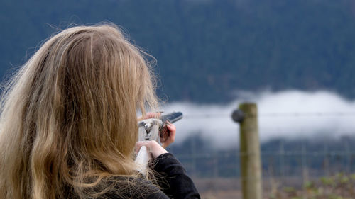 Rear view of woman photographing