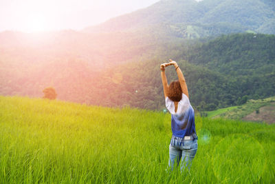 Rear view of woman standing in field