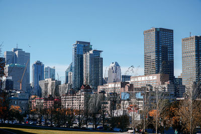 Modern buildings in city against clear blue sky