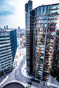 High angle view of modern buildings against sky in city during sunny day