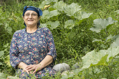 Portrait of smiling senior woman against plants