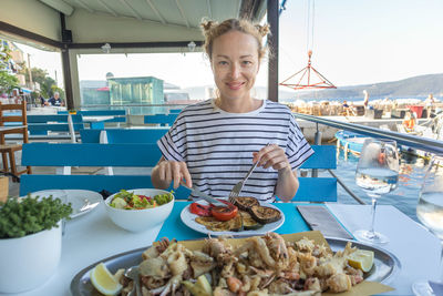 Portrait of woman eating food at restaurant