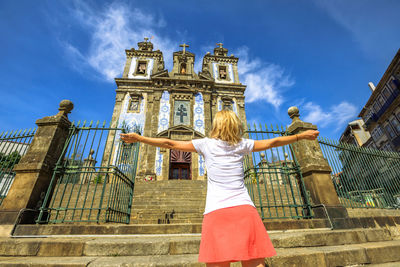 Low angle view of woman standing at historical building