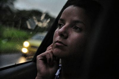Close-up of thoughtful young woman in car