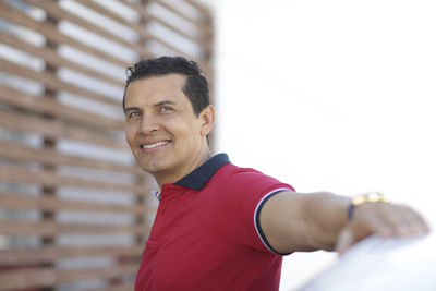 Portrait of smiling man standing against wall