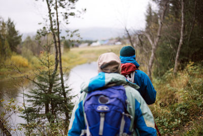 Rear view of people hiking in forest