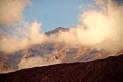 Smoke emitting from volcanic mountain against sky