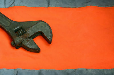 Close-up of metallic object against orange wall