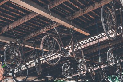 Low angle view of abandoned bicycles hanging from ceiling