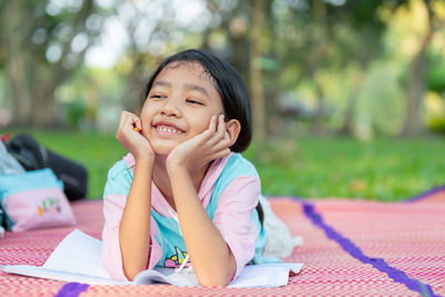 Portrait of smiling girl sitting outdoors