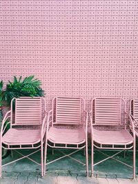 Empty chairs and tables against wall