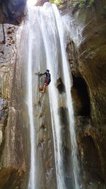 Full length of boy on rock at waterfall