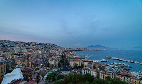 High angle view of city by sea against sky