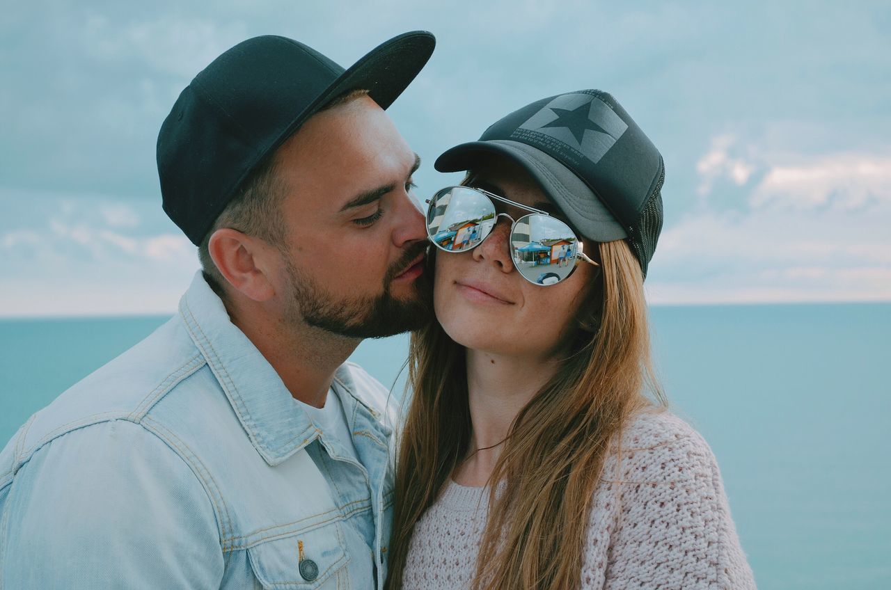 two people, real people, young women, togetherness, love, lifestyles, leisure activity, young adult, sea, young men, casual clothing, outdoors, headshot, bonding, day, focus on foreground, sky, water, nature, eyeglasses, close-up