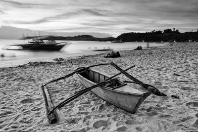 Boat moored on beach against sky