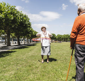 Senior watching elderly lady playing with a hoola hoop